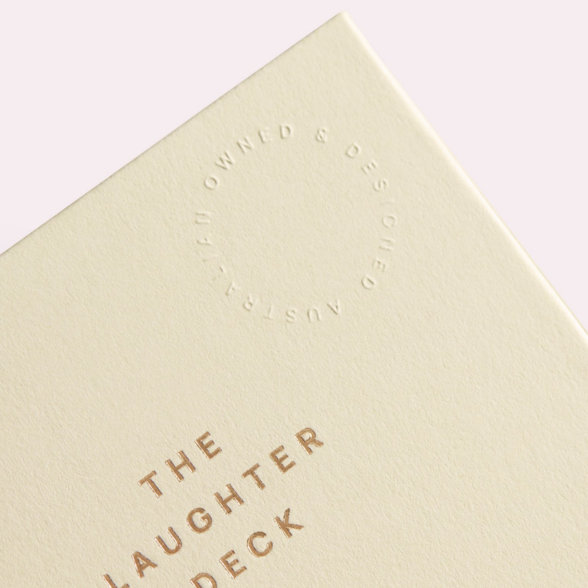 Close-up of the Laughter Deck lid with gold foil lettering and an embossed "Australian owned & designed" seal