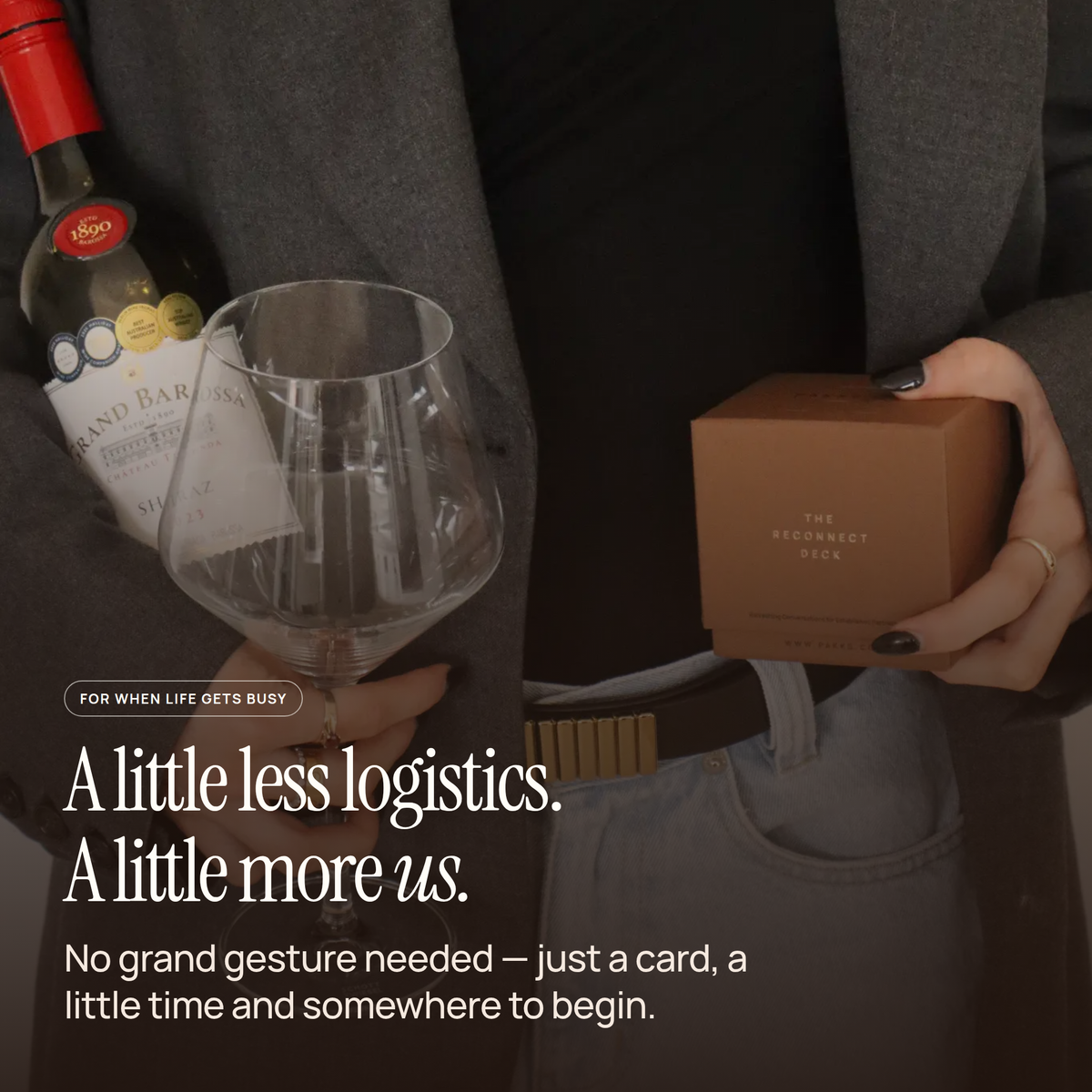 Someone holding a wine bottle, a glass and the Reconnect Deck box, captioned "A little less logistics. A little more us."